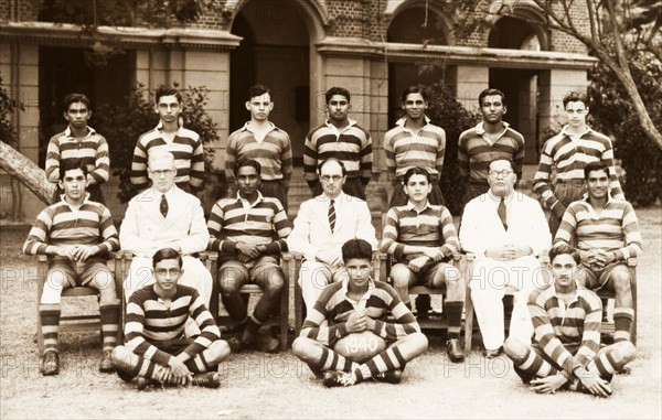 Rugby team at the Royal College of Colombo. Group portrait of a rugby team at the Royal College of Colombo. The young players pose in their rubgy shirts with three members of college staff, including Edward Lawrence Bradby (centre), College Principal between 1939 and 1945. Colombo, Ceylon (Sri Lanka), 1940. Colombo, West (Sri Lanka), Sri Lanka, Southern Asia, Asia.