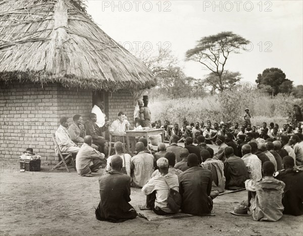 District Commissioner addresses African chiefs. The District Commissioner addresses an audience of African chiefs outside Chief Chiawa's court house in a village in the Zambezi valley. Northern Rhodesia (Zambia), circa 1950. Zambia, Southern Africa, Africa.