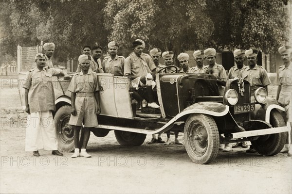 A cadre of Indian Armed Police. A cadre of uniformed Indian Armed Police assemble round a car for a photograph. India, circa 1941. India, Southern Asia, Asia.