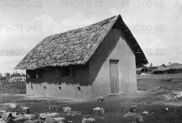 New classroom. A completed timber-frame and plaster classroom, with thatched roof, erected by the local employees of the Kenyan Public Works Department. Waa, Kenya, 1925. Waa, Coast, Kenya, Eastern Africa, Africa.