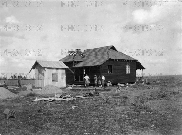 Building a house. This is the last in a series of four photographs showing the rapid erection of a timber-framed European-style house. The photograph shows a back view, with a separate kitchen block, as the house nears completion. The house was built for Charles Bungey, a training officer with the Kenyan Public Works Department, by the local apprentices of his department. Nakuru, Kenya, 1922. Nakuru, Rift Valley, Kenya, Eastern Africa, Africa.