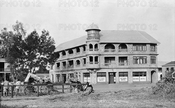 The New Stanley Hotel. Rickshaws parked outside the New Stanley Hotel on a corner of Sixth Avenue. Nairobi, British East Africa (Kenya), 1913. Nairobi, Nairobi Area, Kenya, Eastern Africa, Africa.