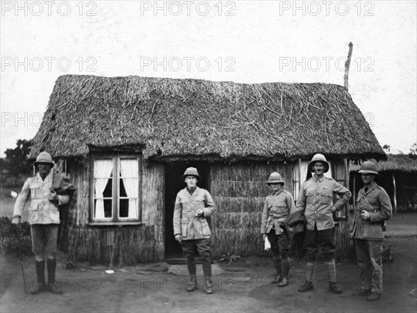 Thatched cottage in the Transvaal. Five European men in army uniform outside a small cottage: either a settler's house or a government outpost. Although constructed of grass and thatch, the cottage is European in style, complete with twin casement windows hung with curtains. Transvaal (Gauteng), South Africa, circa 1915., Gauteng, South Africa, Southern Africa, Africa.