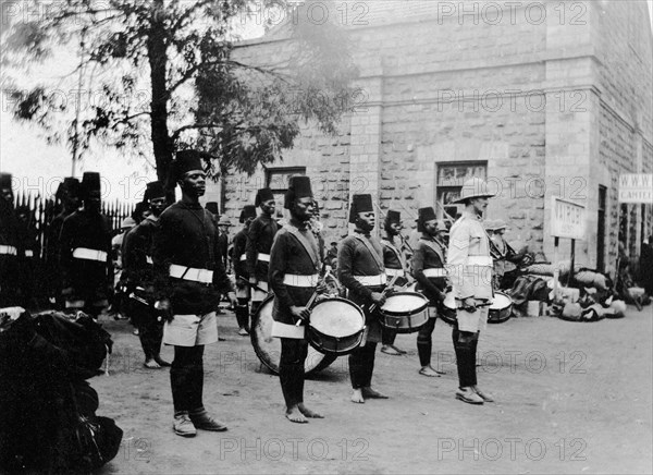 The band of 2/2nd King's African Rifles. A European officer stands at the front of several rows of uniformed African drummers and buglers at Nairobi railway station. Nairobi, British East Africa (Kenya), 1917. Nairobi, Nairobi Area, Kenya, Eastern Africa, Africa.