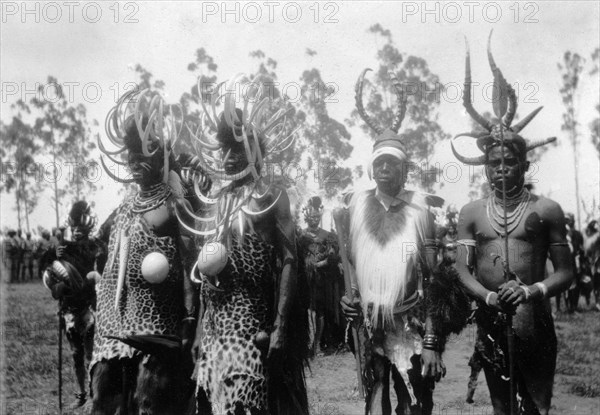 African leaders at the North Kavirondo show. Four African leaders await presentation to the Governor of Kenya at the North Kavirondo agricultural show. They wear headdresses decorated with split hippopotamus tusks, animal hides and hold ostrich eggs. Mumias, Kenya, January 1931. Mumias, West (Kenya), Kenya, Eastern Africa, Africa.