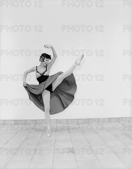 Daphne Dale as Carmen. Dancer Daphne Dale poses for the camera balancing on one toe. Playing the role of Carmen, she is dressed in theatrical dance costume and wears ballet shoes. Kenya, 15 November 1955. Kenya, Eastern Africa, Africa.
