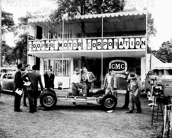 Cooper Motor Corporation. A group of European men chat beside the bare chassis of a car at the Cooper Motor Corporation stand at the Royal Show. Nairobi, Kenya, 28 September-1 October 1955. Nairobi, Nairobi Area, Kenya, Eastern Africa, Africa.