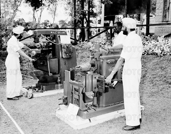 Milling machines at the Royal Show. Two turbaned Indian men demonstrate milling machines at the G & R stand at the Royal Show. Nairobi, Kenya, 28 September-1 October 1955. Nairobi, Nairobi Area, Kenya, Eastern Africa, Africa.