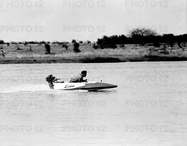 Zipping' along. Ron Richardson scuds across a lake in a small 'Zipp' speedboat during a race at the aquasports club meeting. Nairobi, Kenya, 10 September 1955. Nairobi, Nairobi Area, Kenya, Eastern Africa, Africa.