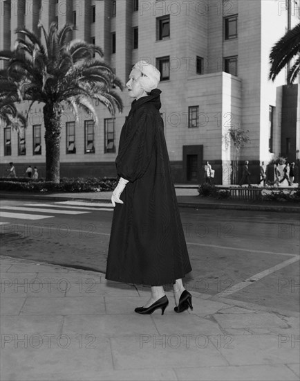 Modelling for Regent. Publicity shot for Regent outfitters. Fashion model Ino poses for the camera in the centre of town wearing a Regent outfit. Kenya, 14 October 1955. Kenya, Eastern Africa, Africa.