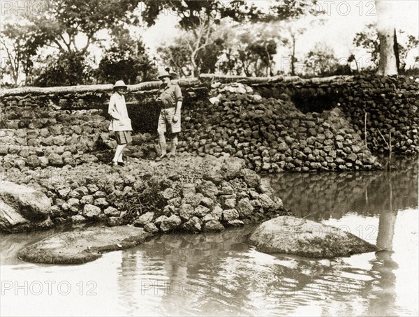 River bridge. Two European men stand on a stone bridge built in January 1928 by Captain Burges Watson over the river Bo. Sudan, circa 1930. Bo (Sudan), West Bahr el Ghazal, Sudan, Eastern Africa, Africa.