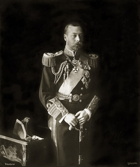 Portrait of King George V. Portrait of King George V of England by court photographers Vandyk of London. Dressed in full military regalia and holding a sword, his cuffs and jacket epaulettes are highly ornate and he wears numerous medals pinned to his chest. Location unknown, circa 1923.