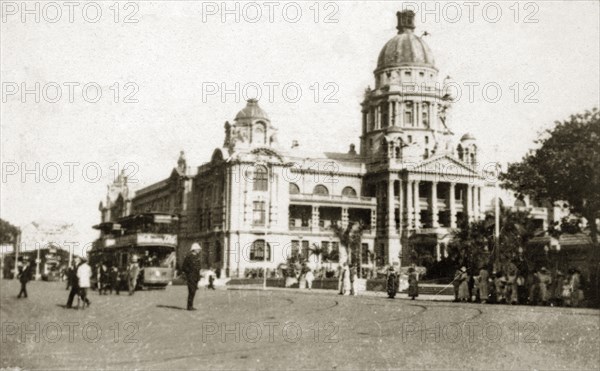 Durban town hall. Street scene outside the town hall in Durban city centre, showing a crowd of people waiting for an oncoming double-decker tram. Durban, Natal (KwaZulu Natal), South Africa, 1-5 January 1924. Durban, KwaZulu Natal, South Africa, Southern Africa, Africa.