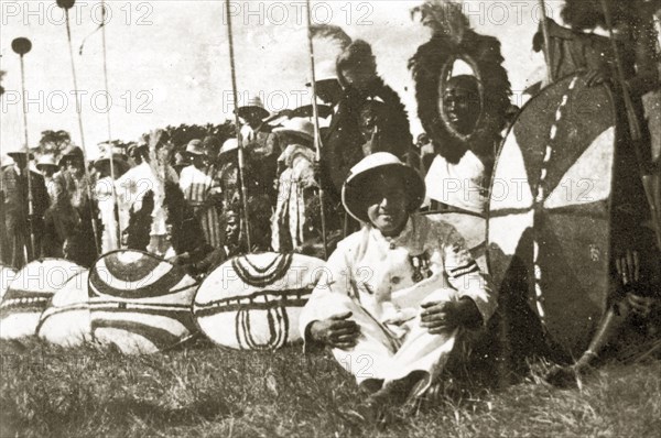 A gathering of African chiefs. A group of African chiefs dressed in ceremonial costume and headdresses, gather before European spectators holding spears and patterned shields. Nairobi, Kenya, 12-17 January 1924. Nairobi, Nairobi Area, Kenya, Eastern Africa, Africa.