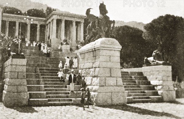 Rhodes monument at Cape Town. Tourists sit on the steps of the Rhodes monument, built in memory of Sir John Cecil Rhodes, the effective founder of the state of Rhodesia in southern Africa. Cape Town, Cape Province (West Cape), South Africa, 22-29 December 1923. Cape Town, West Cape, South Africa, Southern Africa, Africa.