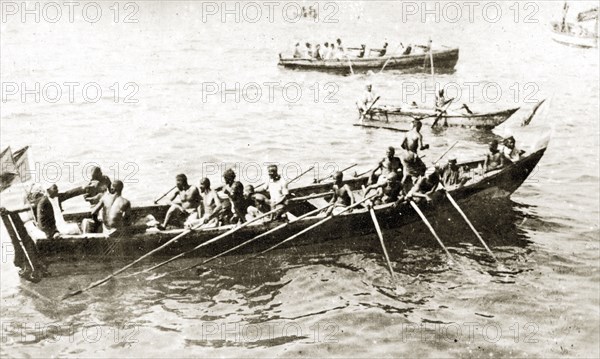 African oarsmen. A group of African oarsmen aboard a narrow barge take a break from rowing. Zanzibar (Tanzania), 12-17 January 1924., Zanzibar Urban/West, Tanzania, Eastern Africa, Africa.