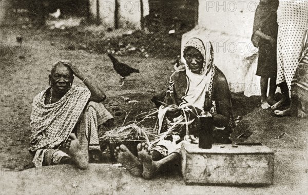 Portrait of two Mombasan women. Portrait of two African women sitting barefoot on a dirt road. Mombasa, Kenya, 12-17 January 1924. Mombasa, Coast, Kenya, Eastern Africa, Africa.