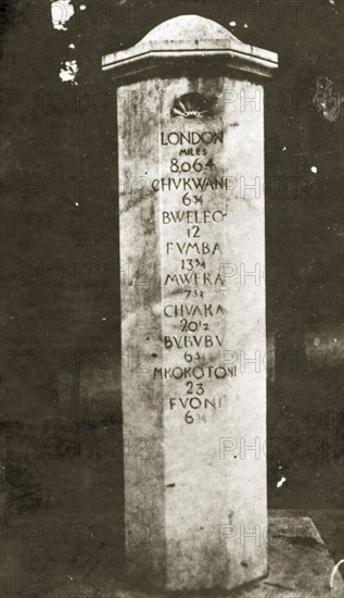 Zanzibar mile post. A stone mile post showing the distance in miles to various cities and towns in Tanzania. At the top of the list is London, recorded as being located 8064 miles away. Zanzibar (Tanzania), 12-17 January 1924., Zanzibar Urban/West, Tanzania, Eastern Africa, Africa.