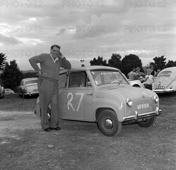 George Arkell's Goggomobil. George Arkell rests his elbow on the top of a Goggomobil car entered as car number 27 in event number three at the Brackenhurst Hill Climb. Kenya, 30 September 1956. Kenya, Eastern Africa, Africa.