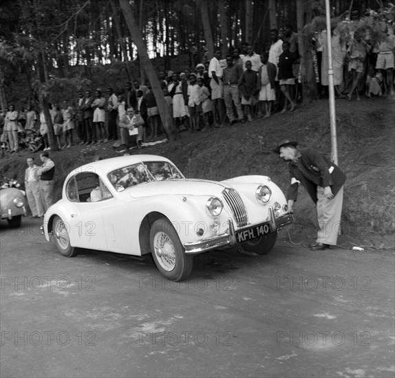 Car inspection at the Brackenhurst Hill Climb. A racing offical inspects a Jaguar car driven by Ron Richardson before the start of event number nine at the Brackenhurst Hill Climb. Limuru, Kenya, 30 September 1956. Limuru, Central (Kenya), Kenya, Eastern Africa, Africa.