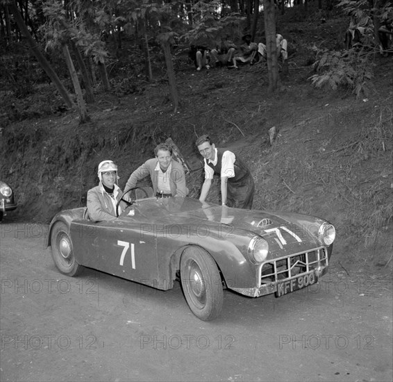 Murdoch drives 'the mouse'. Murdoch sits at the wheel of a sports car nicknamed 'the mouse', posing for the camera with two friends at the start of event number ten at the Brackenhurst Hill Climb. Limuru, Kenya, 30 September 1956. Limuru, Central (Kenya), Kenya, Eastern Africa, Africa.