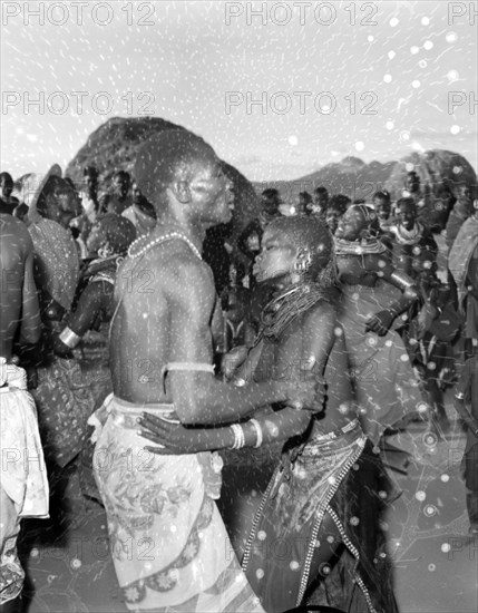 A Turkana couple dancing. A Turkana couple wearing traditional dress and jewellery are absorbed in the moment as they perform a dance at a 'ngoma'. Wamba, Kenya, 13 October 1956. Wamba, Rift Valley, Kenya, Eastern Africa, Africa.