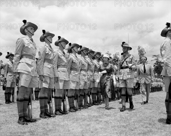 Princess Margaret inspects a Guard of Honour. European soldiers comprising a Guard of Honour stand to attention in uniformed rows as Princess Margaret inspects them. A ranking officer accompanies the Princess, holding an upright sword in his left hand. Kenya, 19 October 1956. Kenya, Eastern Africa, Africa.
