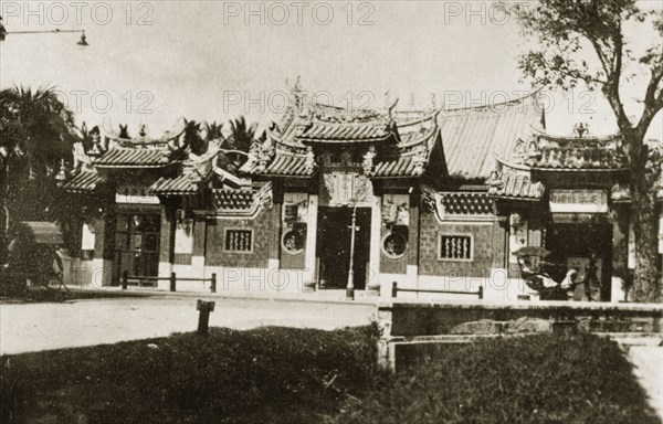 Kuan Yin See temple. Roadside view of Kuan Yin See, a Chinese temple of the Goddess of Mercy located on Burmah Road. The temple has a pagoda-style roof and decorative fretwork windows. Georgetown, British Malaya (Malaysia), 4-8 February 1924. Georgetown, Penang, Malaysia, South East Asia, Asia.