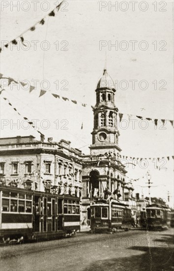 Adelaide town hall. Strings of bunting festoon the road above trams passing in front of the town hall. Adelaide, Australia, 10-15 March 1924. Adelaide, South Australia, Australia, Australia, Oceania.