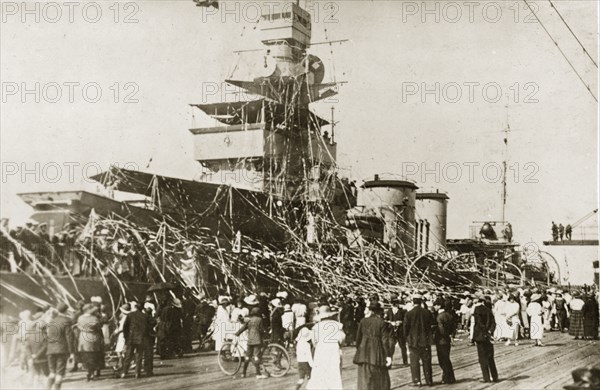 Competition for the highest streamers. British Special Service Squadron crew members aboard HMS Delhi throw streamers into the crowd who have gathered to watch their departure. Melbourne, Australia, 17-25 March 1924. Melbourne, Victoria, Australia, Australia, Oceania.