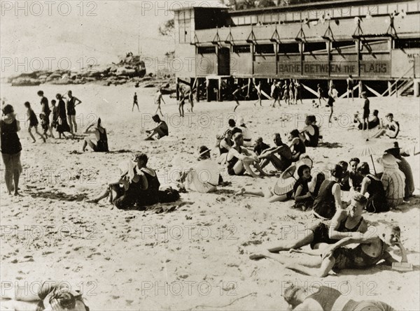 Bathers on Manley beach. Bathers wearing swimming costumes relax on the sand at Manley beach. Sydney, Australia, 9-12 April 1924. Sydney, New South Wales, Australia, Australia, Oceania.