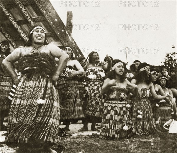 Maori singers. A group of Maori women perform a welcoming song dressed in their traditional costume of 'piupius' (woven flax skirts) and patterned 'tipares' (headbands). Rotorua, New Zealand, 10-17 May 1924. Rotorua, Bay of Plenty, New Zealand, New Zealand, Oceania.