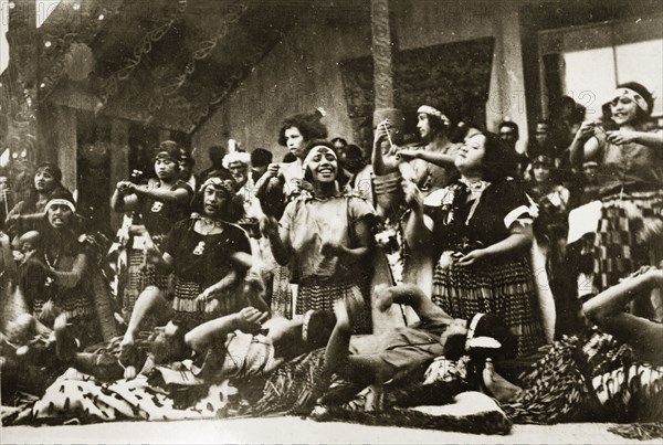 Maori dancers. A group of Maori women perform a lively dance dressed in their traditional costume of 'piupius' (woven flax skirts) and patterned 'tipares' (headbands). Probably Rotorua, New Zealand, 10-17 May 1924. Rotorua, Bay of Plenty, New Zealand, New Zealand, Oceania.