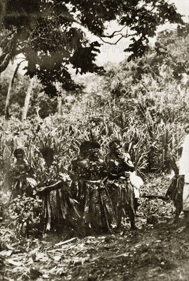 Fijian firewalkers. A group of Fijian men wear traditional dress consisting of tassled skirts, garlands of leaves and headbands. They are identified as 'firewalkers', people able to walk barefoot over hot coals. Fiji, 21-27 May 1924. Fiji, Pacific Ocean, Oceania.