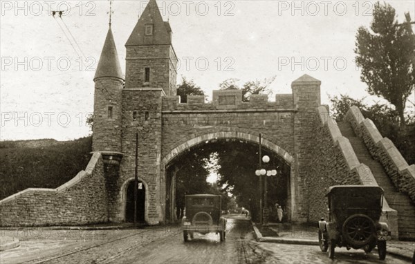 St Louis Gate, Quebec. Cars drive beneath the arched gateway and tower of St Louis Gate. Quebec, Canada, 18 August-2 September 1924. Quebec, Quebec, Canada, North America, North America .