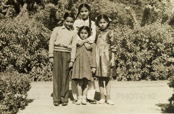 Four Indian children. Four Indian children dressed in Western-style clothing, pose obediently for the camera. India, circa 1954. India, Southern Asia, Asia.