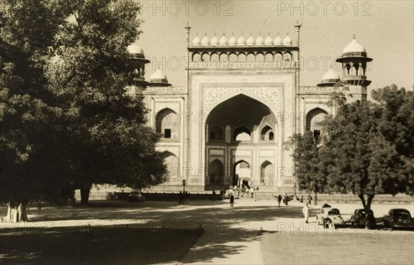 Gateway to the Taj Mahal. Tourists pass through the Darwaza, the decorative gateway built from red sandstone that forms the entrance to the Taj Mahal complex. Agra, Uttar Pradesh, India, circa 1954. Agra, Uttar Pradesh, India, Southern Asia, Asia.