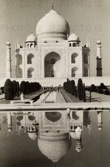 Reflection of the Taj Mahal. The Taj Mahal reflected in a pool belonging to its formal 'charbagh' gardens. The monument features a famous onion-shaped dome and several minarets typical of Mughal architecture. Agra, Uttar Pradesh, India, circa 1954. Agra, Uttar Pradesh, India, Southern Asia, Asia.
