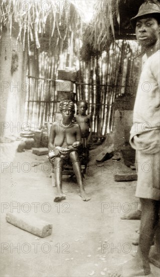 Five minutes old. A mother holds her five minute old baby, accompanied by her husband and son. Western Africa, circa 1918., Western Africa, Africa.