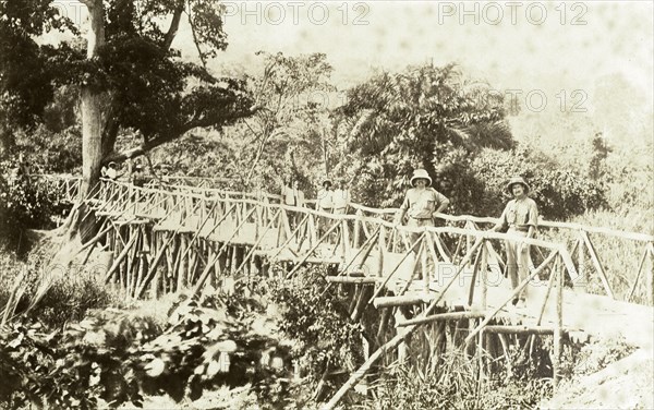 Timber bridge near Accra. Europeans and Africans pose for the camera on a timber bridge near Accra. East Gold Coast (Ghana), 1918., East (Ghana), Ghana, Western Africa, Africa.