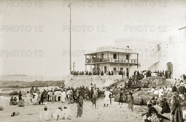 Cape Coast and SS Karina. View of an official building, possibly a customs house, at Cape Coast. The SS Karina can be seen in the background, a ship that was torpedoed by the Germans on 1 August 1917. Cape Coast, Gold Coast (Ghana), 1917. Cape Coast, Central (Ghana), Ghana, Western Africa, Africa.