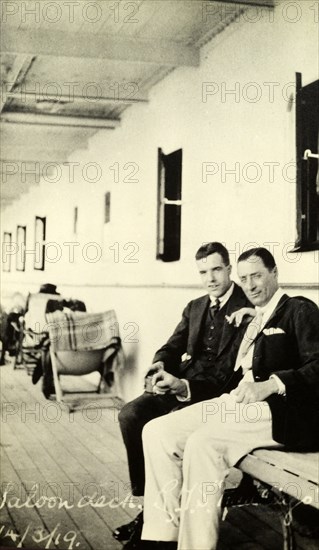 Tamlin on deck. Two gentlemen chat on the saloon deck of a passenger ship. The man on the left is Alfred Tamlin. Location unknown, 14 March 1919.