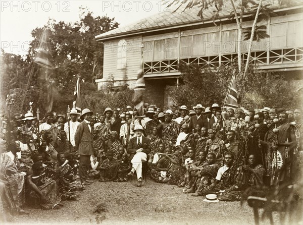 Meeting between British and Asante leaders. British Chief Commissioner, Charles Harper (centre), poses for a group portrait with Asante (Ashanti) leaders, including the Mensa of Kumasi, outside his official residence. Kumasi, Gold Coast (Ghana), circa 1920. Ghana, Western Africa, Africa.