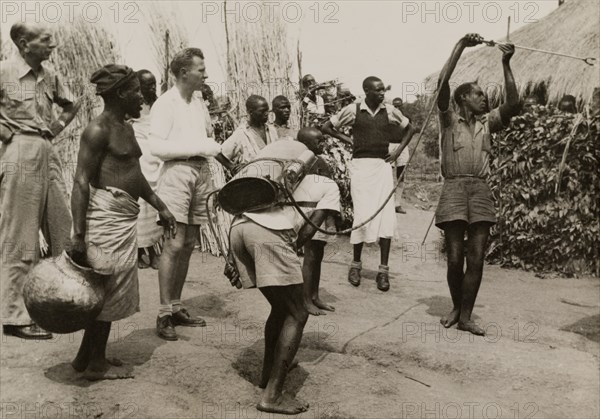 Spraying pesticide at a Congolese village. A team of men use a portable atomiser to spray vegetation with pesticide on the outskirts of a Congolese village. Belgian Congo (Democratic Republic of Congo), 1950. Congo, Democratic Republic of, Central Africa, Africa.