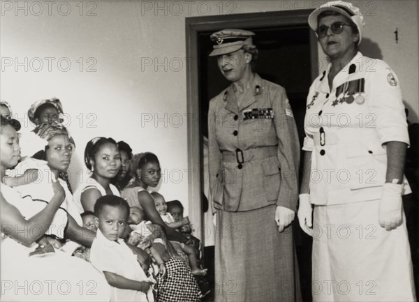 Princess Mary visits a British Red Cross clinic, Nigeria. Princess Mary, Countess of Harewood, is accompanied by a Regional Nursing Superintendent as she visits a Children's Welfare Clinic run by the British Red Cross. The Princess Royal had been appointed Member first class of the Royal Red Cross (RRC) in 1953. Enugu, Anambra State, Nigeria, 16 November 1957. Enugu, Anambra, Nigeria, Western Africa, Africa.