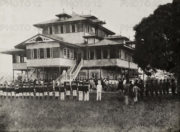 Empire Day at the Vice Consulate of Bonny. Lines of uniformed Nigerian men take part in a parade for Empire Day outside the Vice Consulate of Bonny. Bonny, Nigeria, 24 May 1907. Bonny, Rivers, Nigeria, Western Africa, Africa.