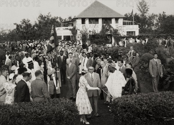 Queen Elizabeth II at a garden party in Nigeria. Queen Elizabeth II shakes hands with a Nigerian dignitary at a garden party in the grounds of a government house, during her royal tour of Nigeria (28 January-16 February 1956). Nigeria, circa January 1956. Nigeria, Western Africa, Africa.