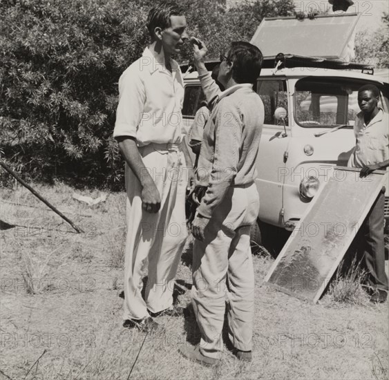 On location with the Central African Film Unit. A crew member of the Central African Film Unit (CAFU) powders the nose of an actor on the set of a film shoot. Probably Southern Rhodesia (Zimbabwe), circa 1955. Zimbabwe, Southern Africa, Africa.