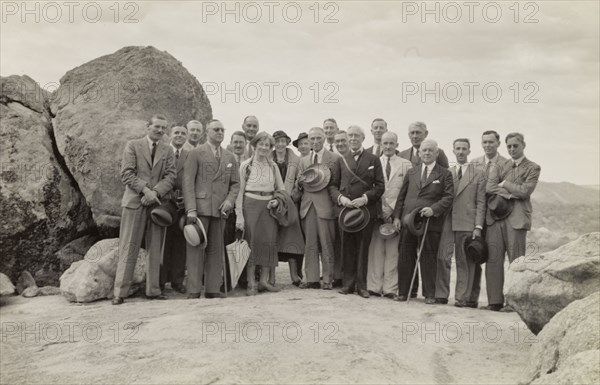 Members of the Bledisloe Commission. Members of the Bledisloe Commission pose for a group portrait on top of a rocky outcrop. Amongst the group are the Head of the Commission, Lord Bledisloe, and other prominent Commissioners including William Mainwaring and Ian Orr Ewing. Southern Africa, 1937., Southern Africa, Africa.