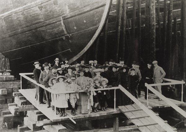 Henry Bell Wortley at a dockyard. A group of formally dressed adults and children stand on a platform beside the bow of a large ship in dry dock. Amongst the group is Henry Bell Wortley (far right), a naval architect and ship designer for the Blue Funnel Line. United Kingdom, circa 1890. England (United Kingdom), Western Europe, Europe .